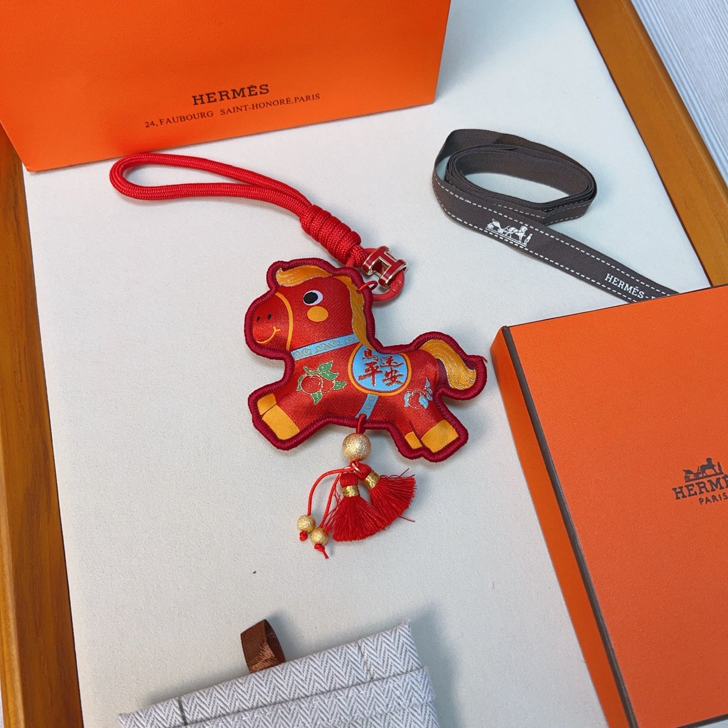 Hermes Year of the Horse Lucky Tassel Charm pendant Red fabric with gold blue green decorative details red cord strap gold-tone metal hardware red tassels 12cm total length