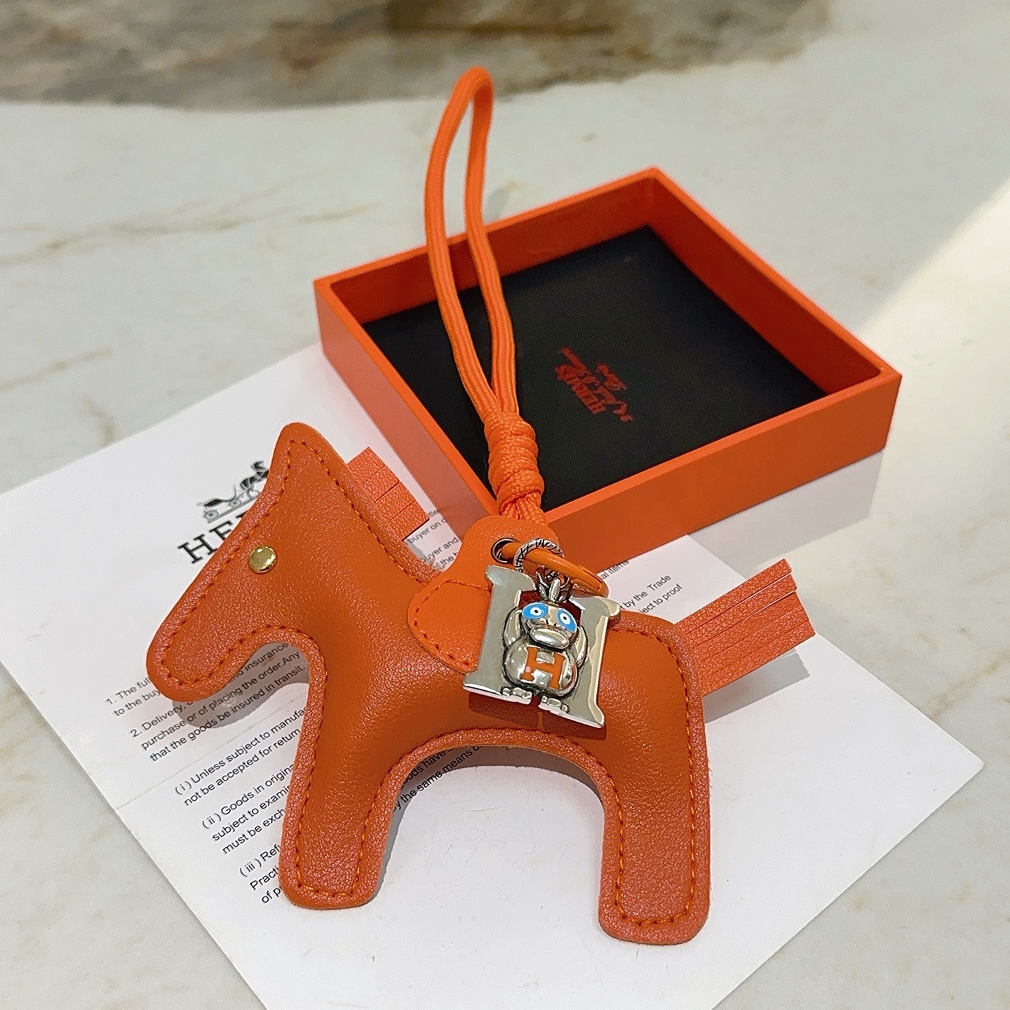 Hermes Rodeo Pegase Horse Charm con H Monkey Colgante colgante de cuero naranja con metal plateado detalles en esmalte azul y naranja remache dorado 8 cm