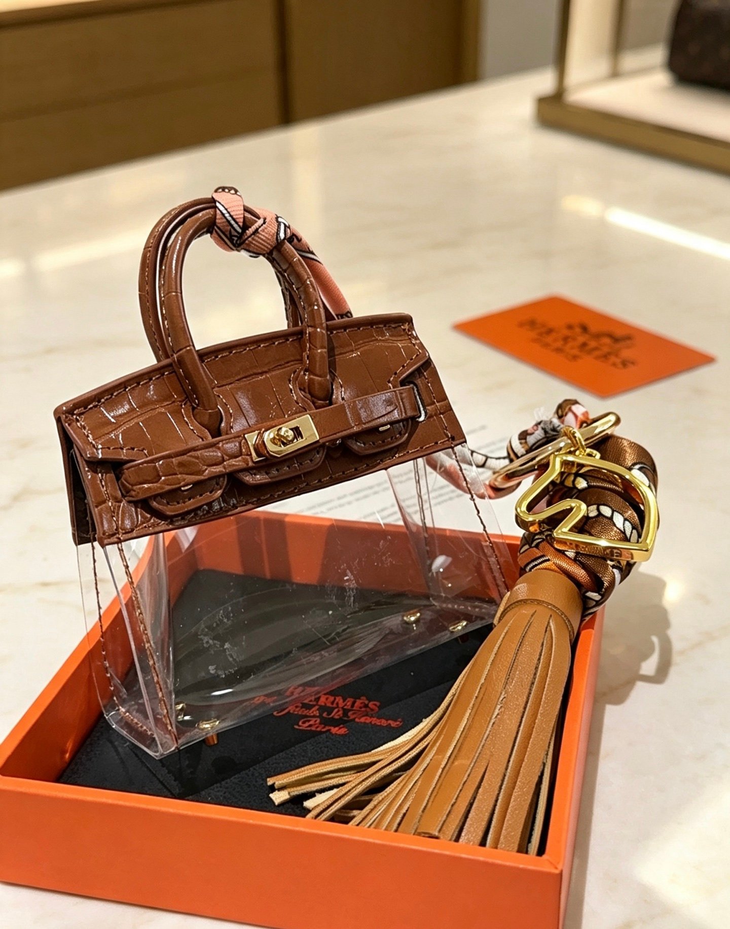 Hermes Birkin Micro Bag Charm pendant Gold-tone metal brown crocodile-embossed leather transparent PVC tan leather tassel multicolor printed silk twilly 12cm total length