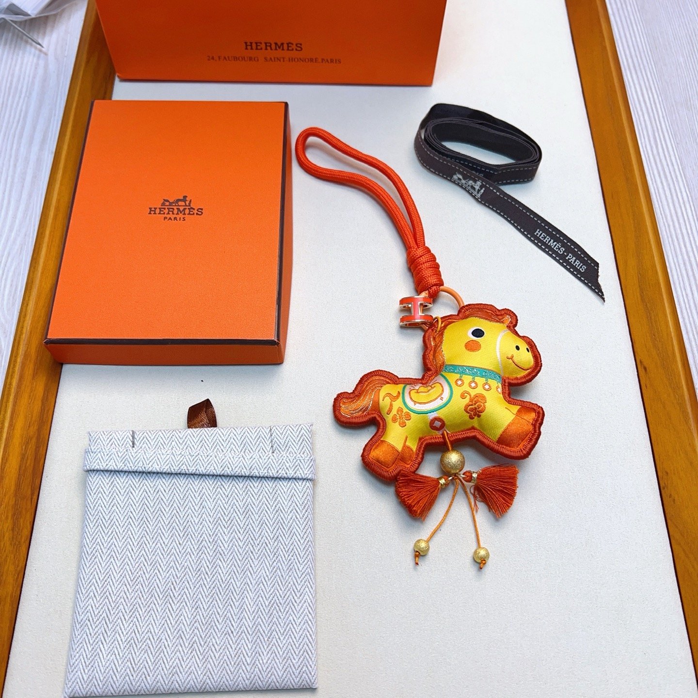 Hermes Year of the Horse Charm Keychain pendant Orange enamel H hardware yellow fabric horse charm with orange embroidery orange cord strap gold tone metal beads orange tassels 12cm strap length