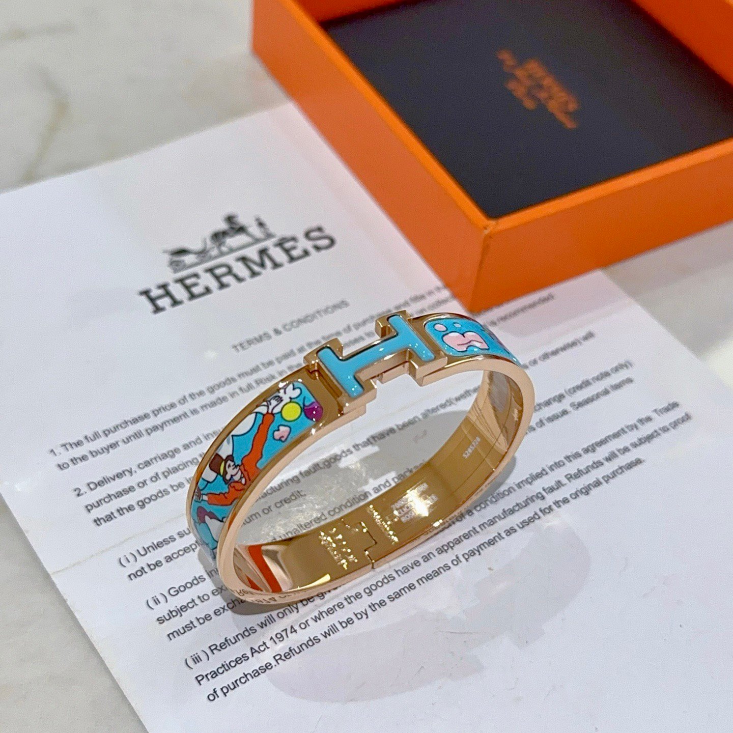 Hermes Clic Clac H bracelet Rose gold plated metal with light blue enamel featuring multicolor cartoon print PM