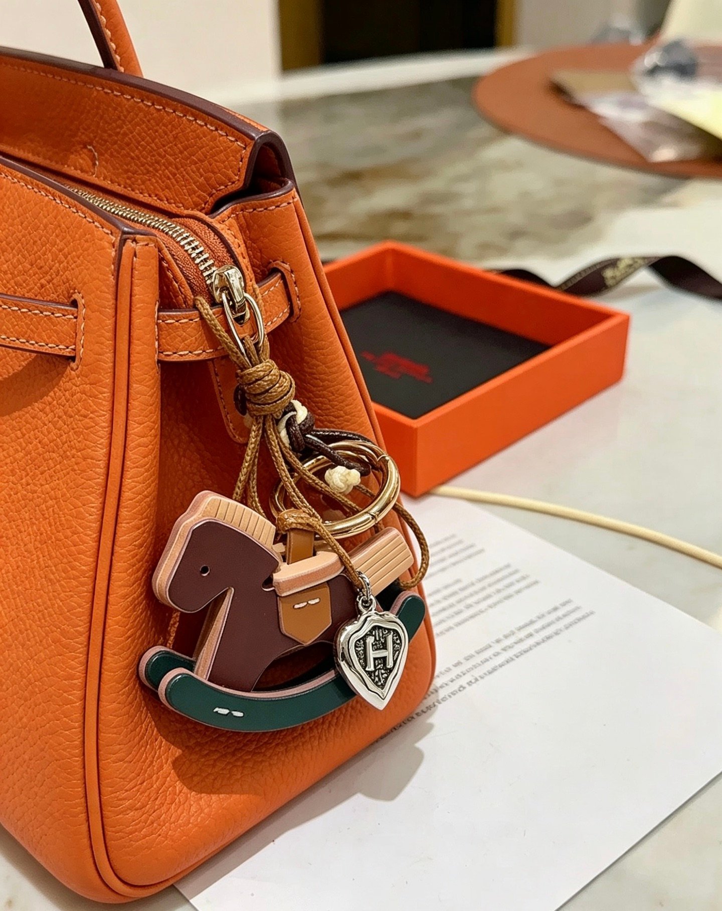Hermes Rocking Horse Bag Charm pendant Gold-tone metal silver-tone shield charm brown leather dark green leather tan leather cream leather brown and cream braided cord 12cm total strap length