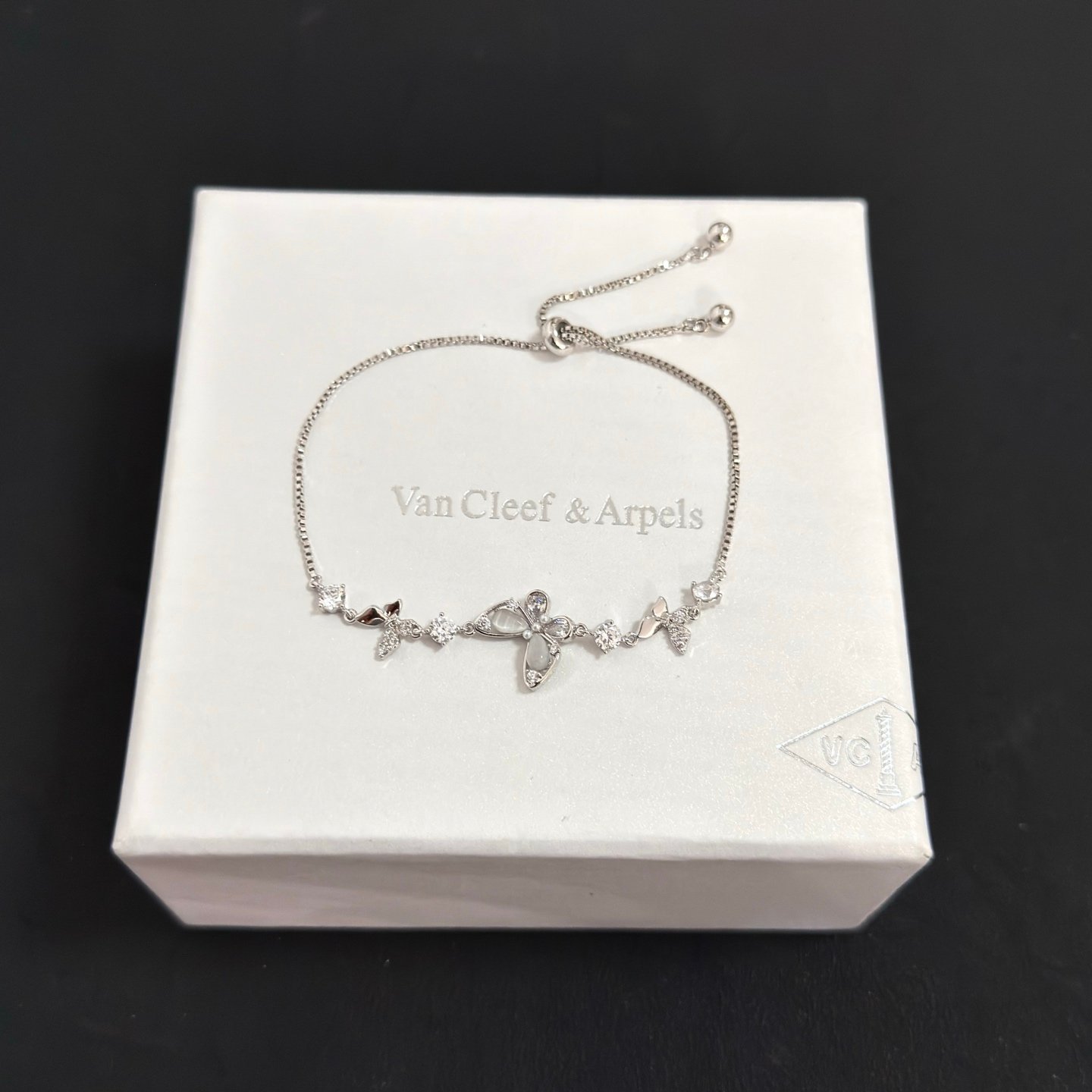 Bracciale regolabile Van Cleef Arpels con motivo a farfalla intarsiato con diamanti Metallo in oro bianco color argento con accenti di diamanti chiari e intarsi a farfalla in madreperla Chiusura scorrevole regolabile per polsi da 15-20 cm