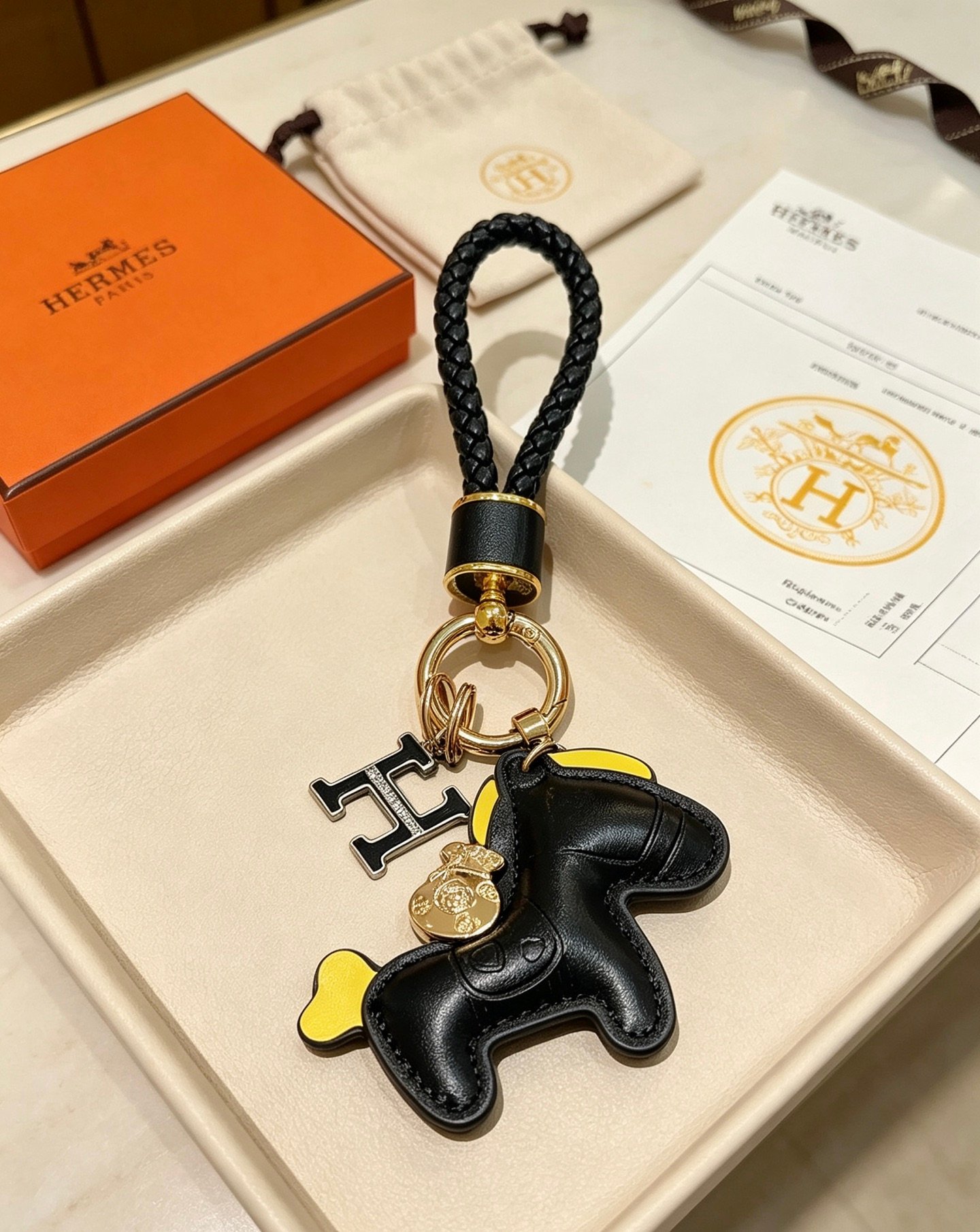 Hermes Rodeo Pony H logotipo trançado chaveiro pingente couro preto amarelo acento dourado metal preto esmalte H charme 12 cm comprimento total