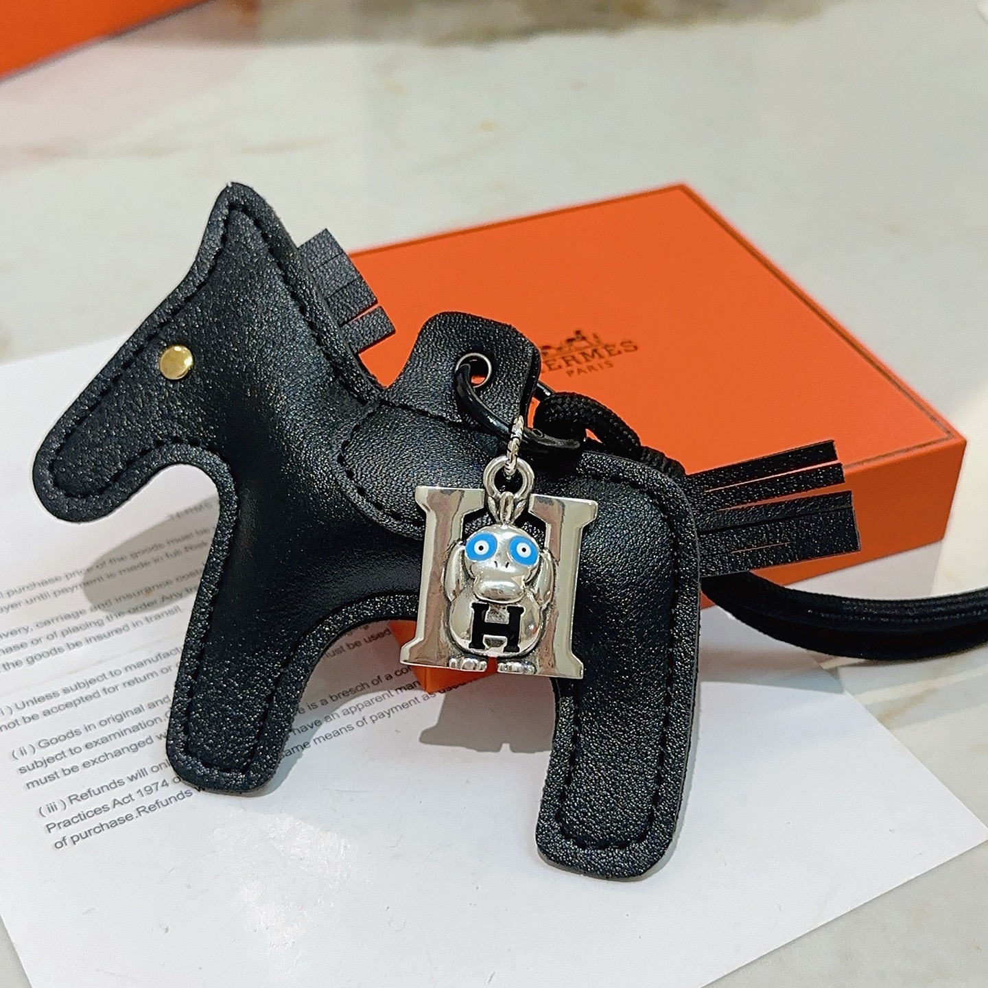 Hermes Rodeo Monkey H Bag Charm Llavero colgante Cuero negro metal plateado esmalte azul detalle de metal dorado 8 cm